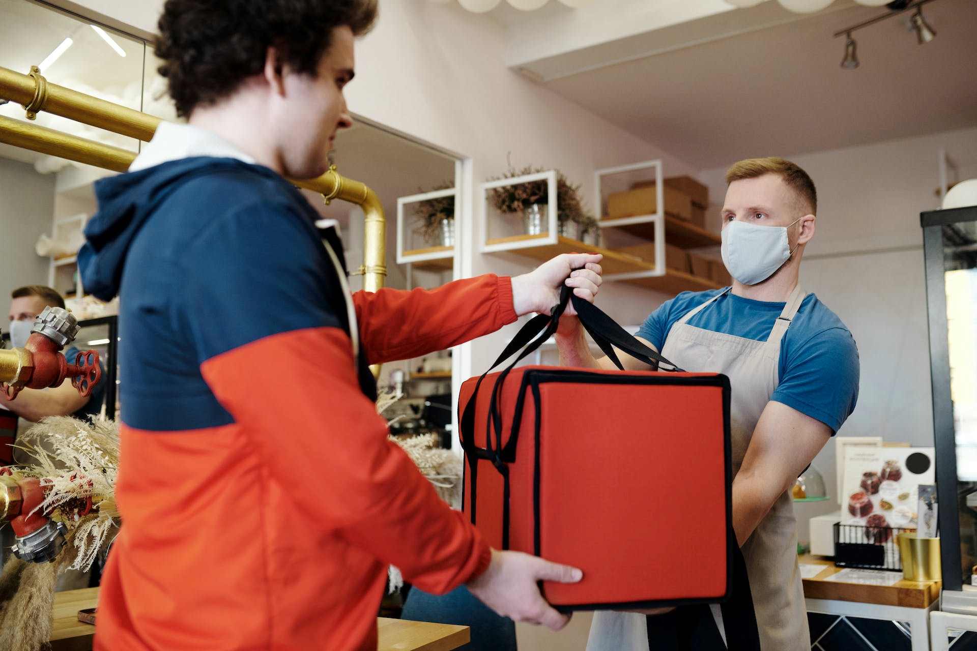 a person handing over a thermal bag to another person