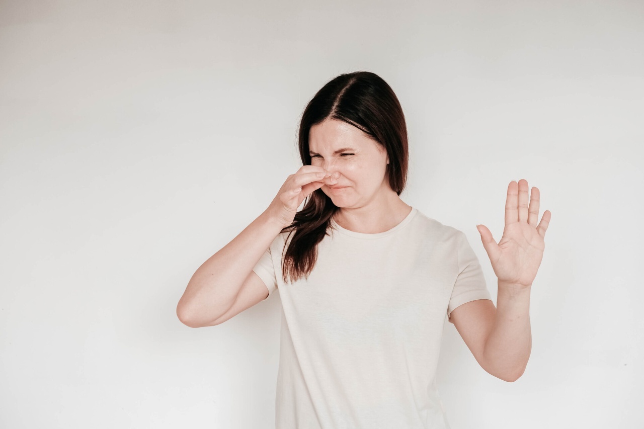 Woman dressed in casual white t shirt grimacing with disgus