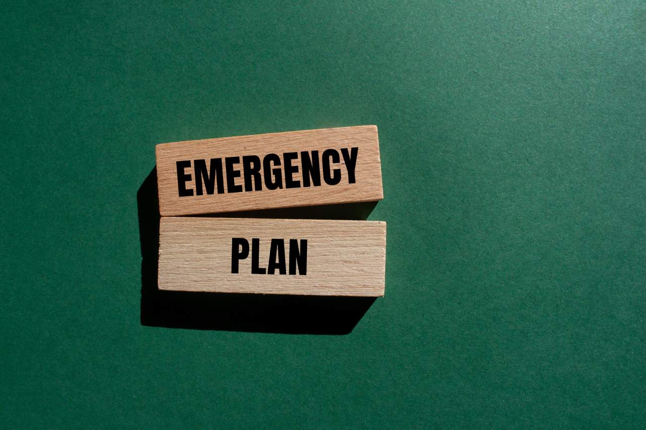 Emergency plan message written on wooden blocks with green background