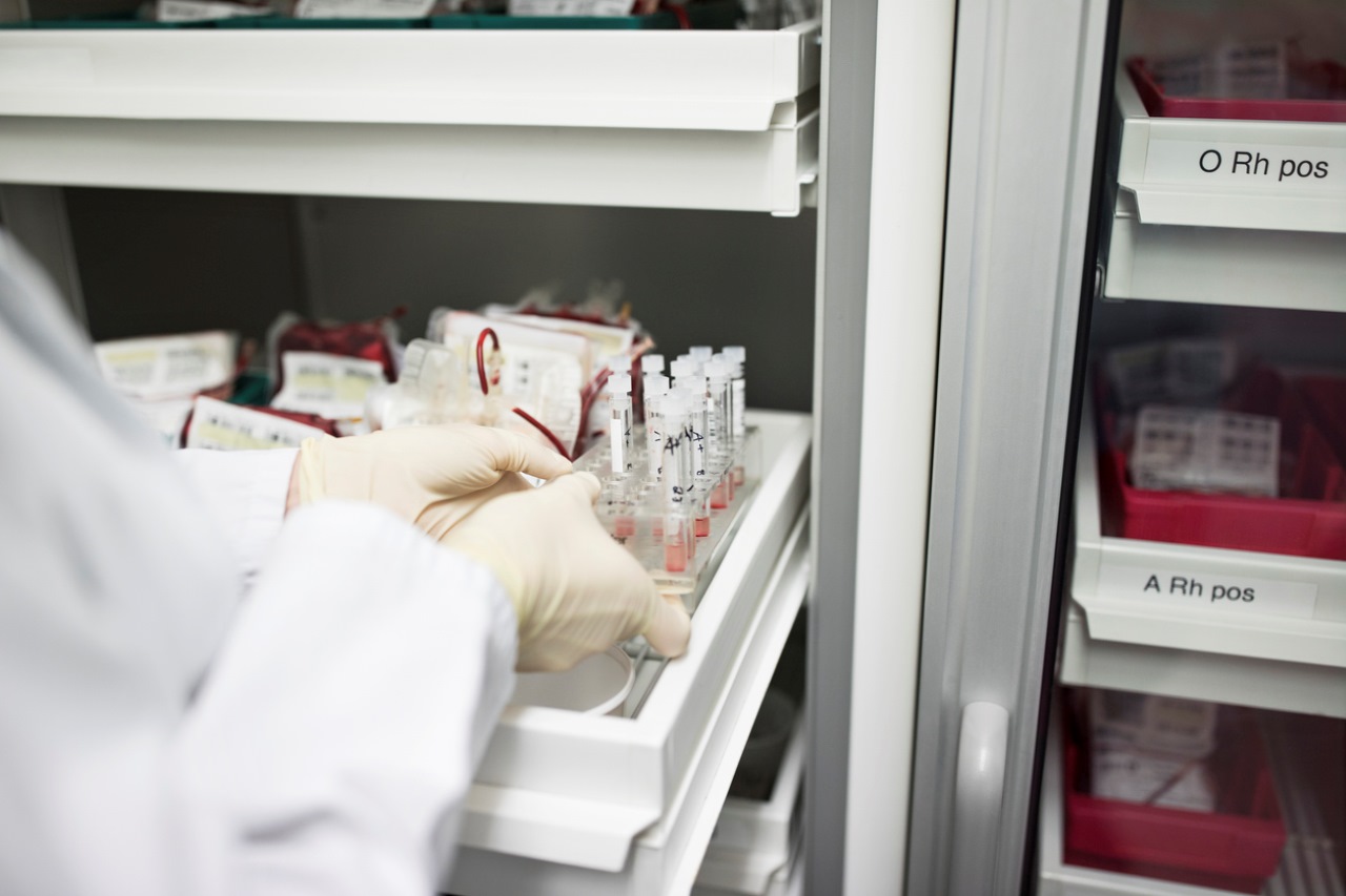 scientist putting samples in refrigerator at laboratory